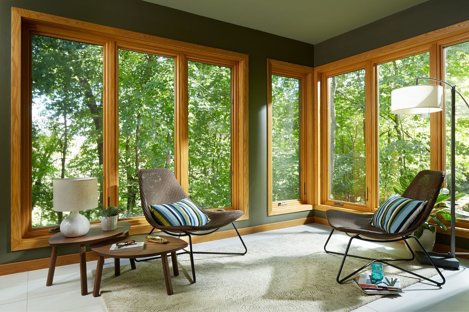 Interior view of a living room with floor-to-ceiling casement windows all around. 