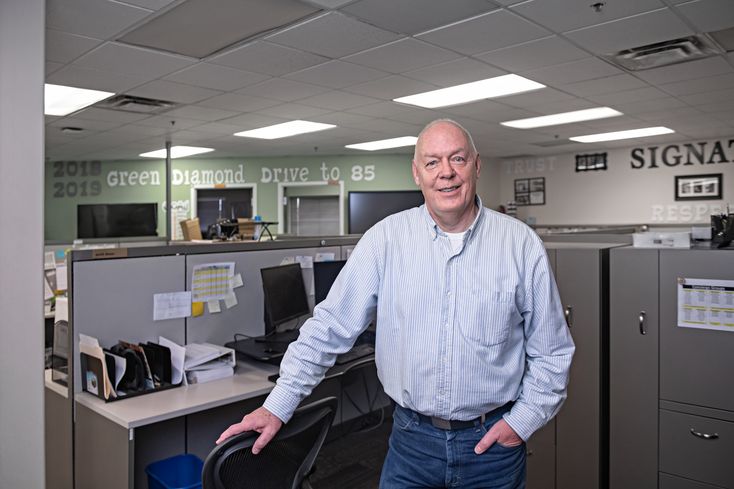 A Renewal by Andersen Retail Service Representative standing infront of his desk