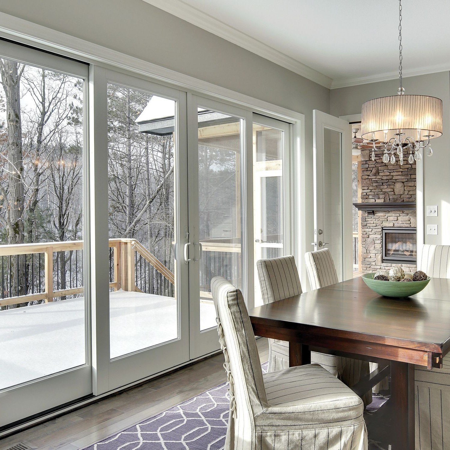 Traditional-style sliding glass doors in a kitchen. The doors are white a-series. The middle two slide open.