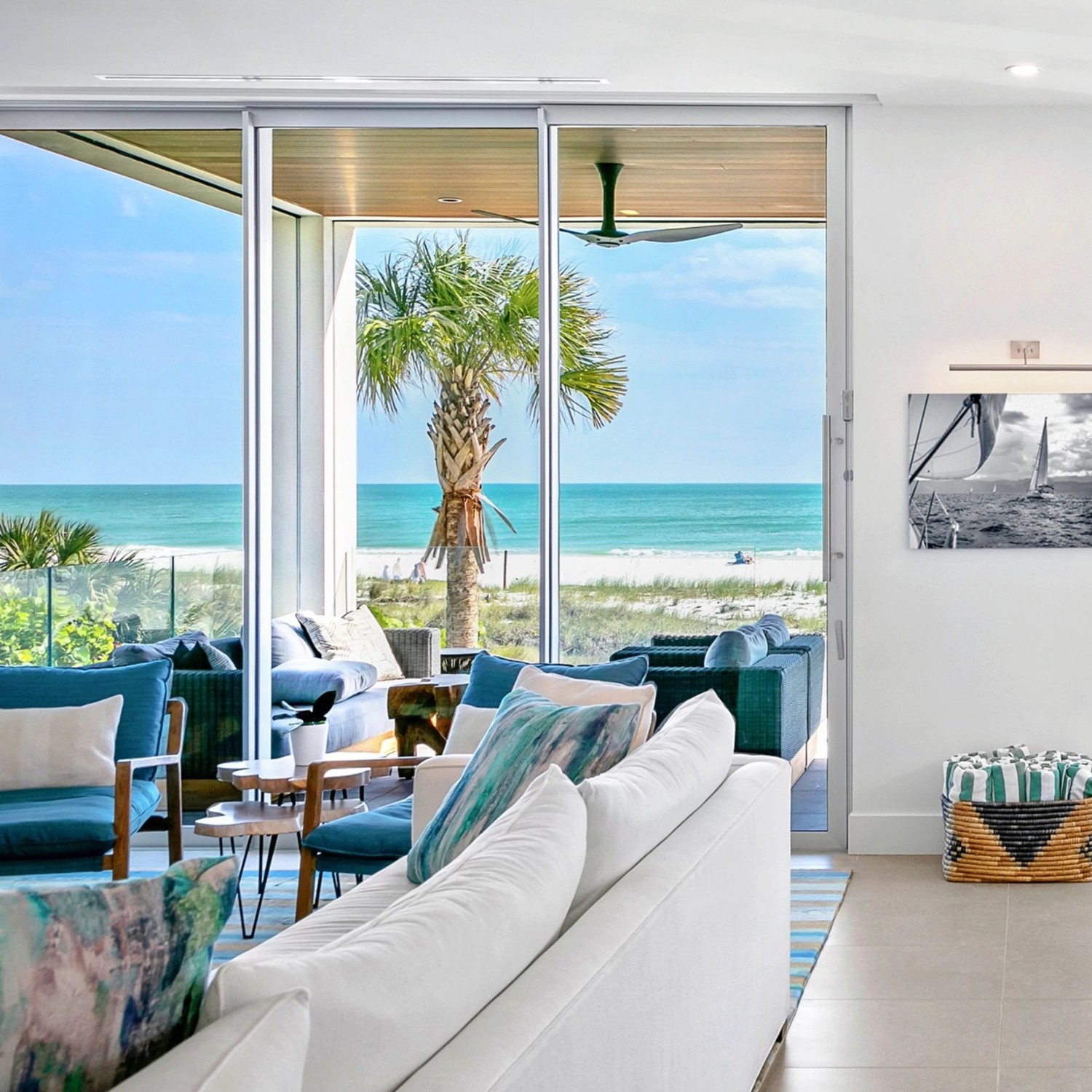 A view of palm trees and water. We are looking past the couch and out the doors.