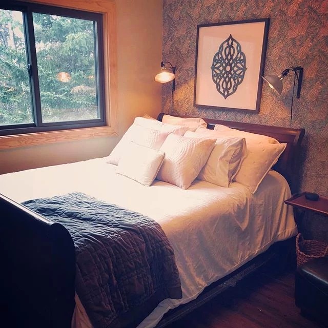 A softly lit bedroom with a gliding or sliding window above the bed.